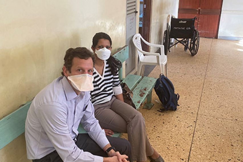 Josh Easter and Amita Sudhir Seated on a Bench Inside Hospital in Kenya
