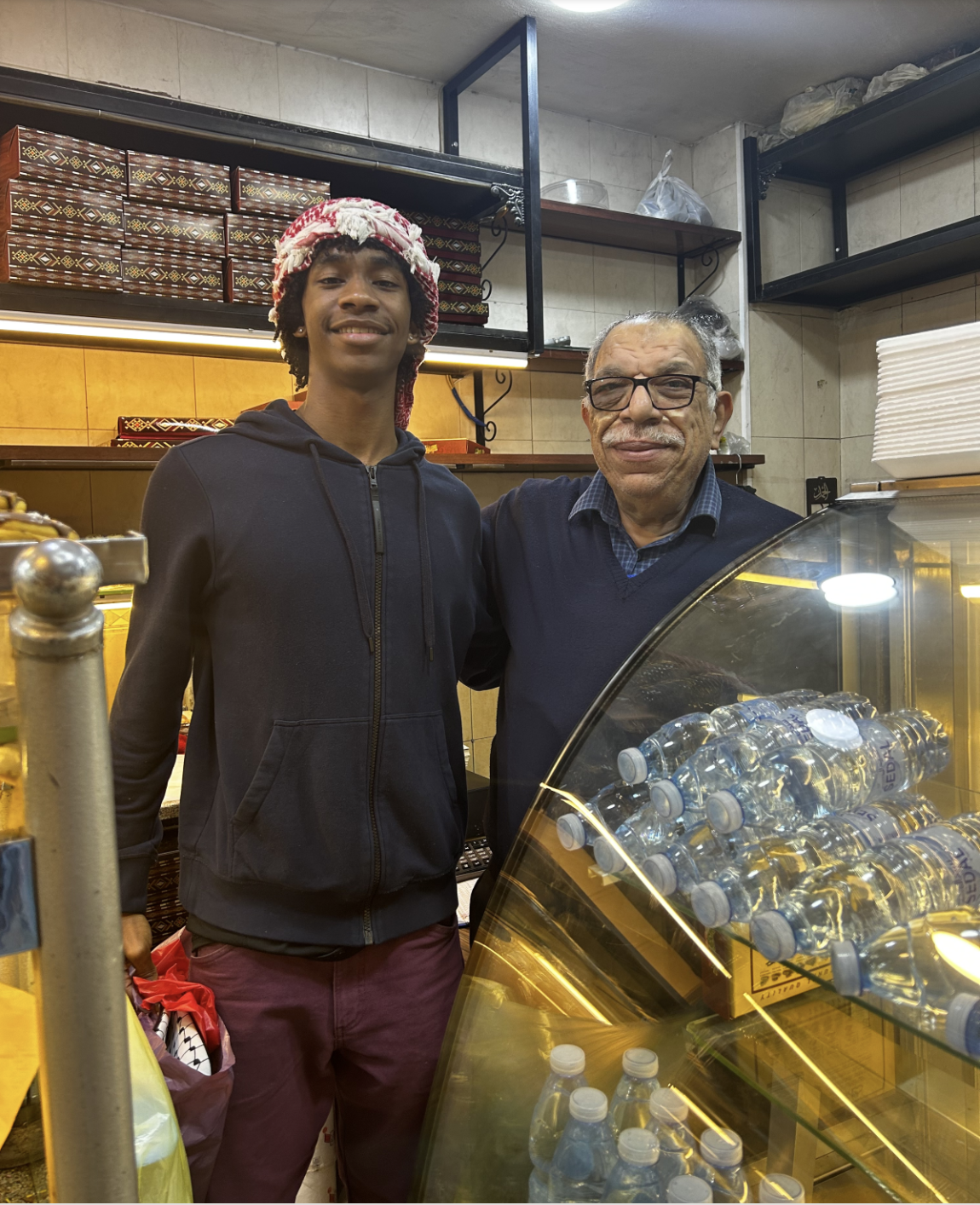 Smith with arm around a man in a shop in Amman