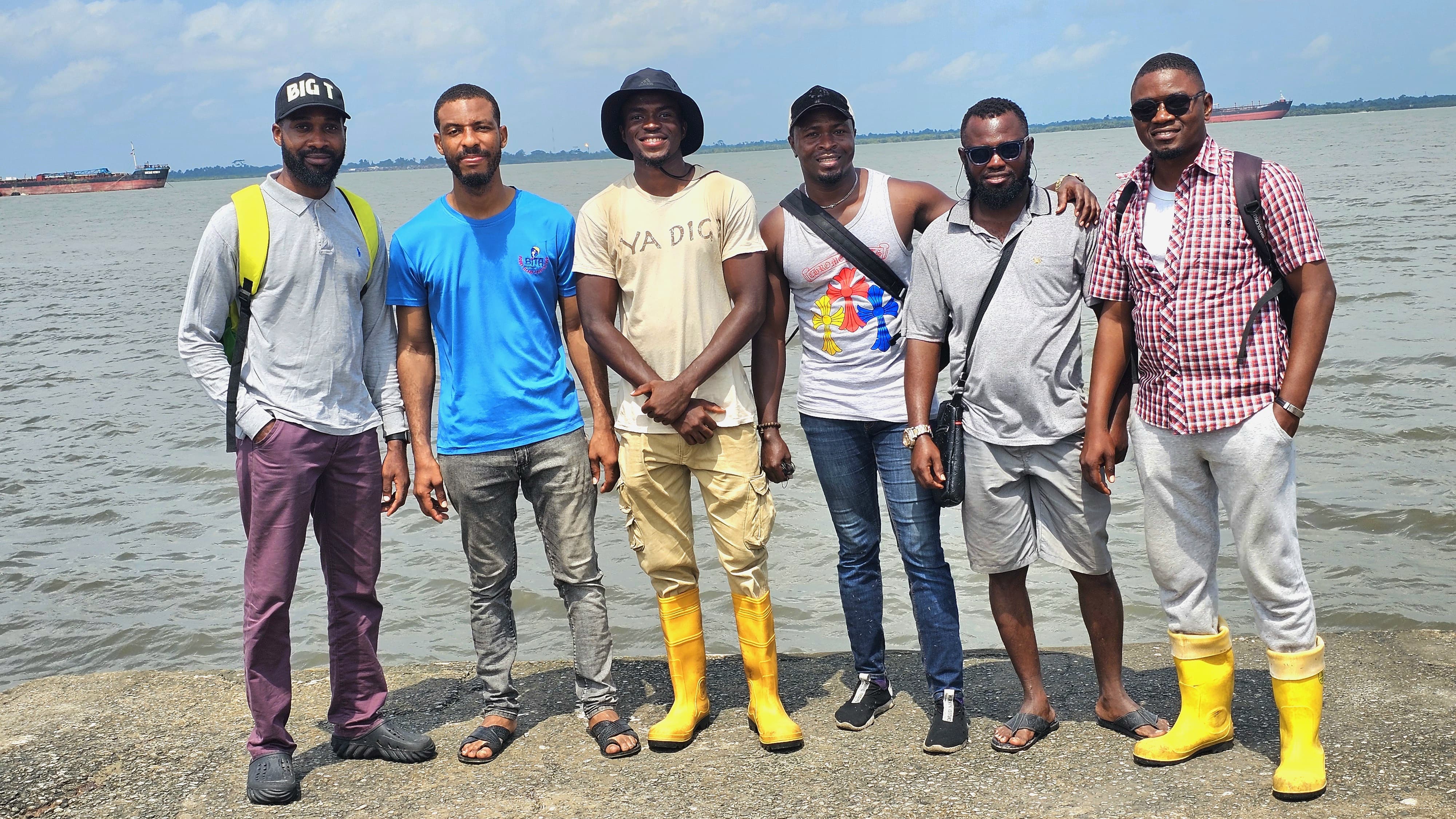Omigbule with friends posing in front of the ocean.