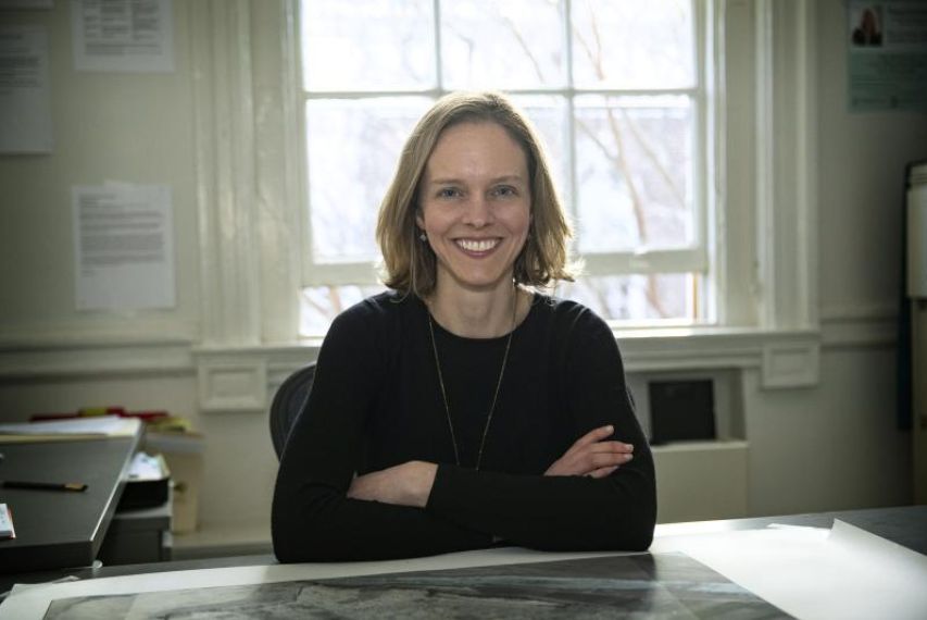 Fiona Greenland sitting at a desk with arms crossed