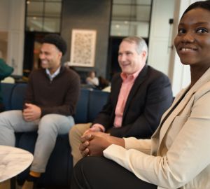 Precious Ezealigo sitting in focus with others chatting in background
