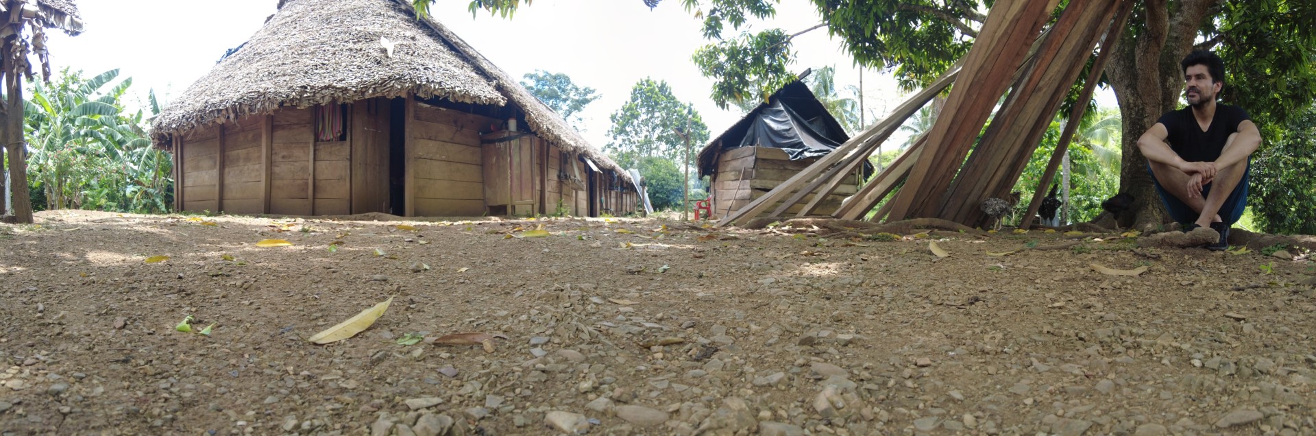Vargas sitting on the ground near dwelling in Kuna community in Darién Tropical Rain Forest
